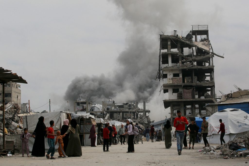 Palestinos corren a refugiarse mientras un ataque israelí impacta la casa de la familia Hmeid en Jabalia, en el norte de la Franja de Gaza, el 15 de mayo de 2025. Los combates han continuado en Gaza, donde funcionarios de defensa civil informaron a AFP que 80 personas fueron asesinadas por bombardeos israelíes el 14 de mayo, incluyendo 59 en el norte. (Foto de Bashar TALEB / AFP) (Foto de BASHAR TALEB/AFP a través de Getty Images)